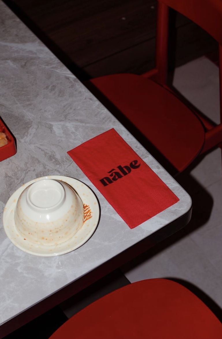 Bowl and red nābe napkin on stone